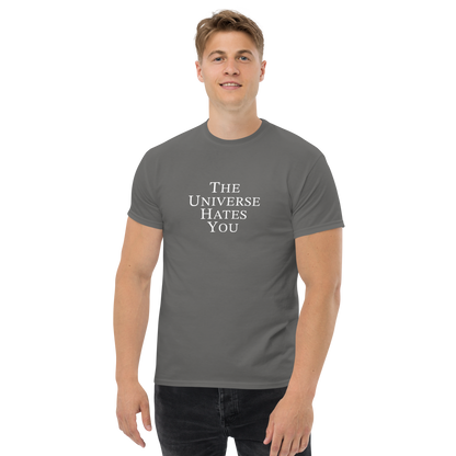 "The Universe Hates You" printed on a charcoal unisex classic tee worn by a male