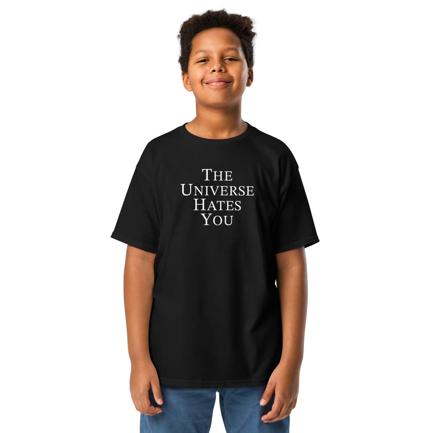 "The Universe Hates You" printed on a black youth classic tee worn by a male