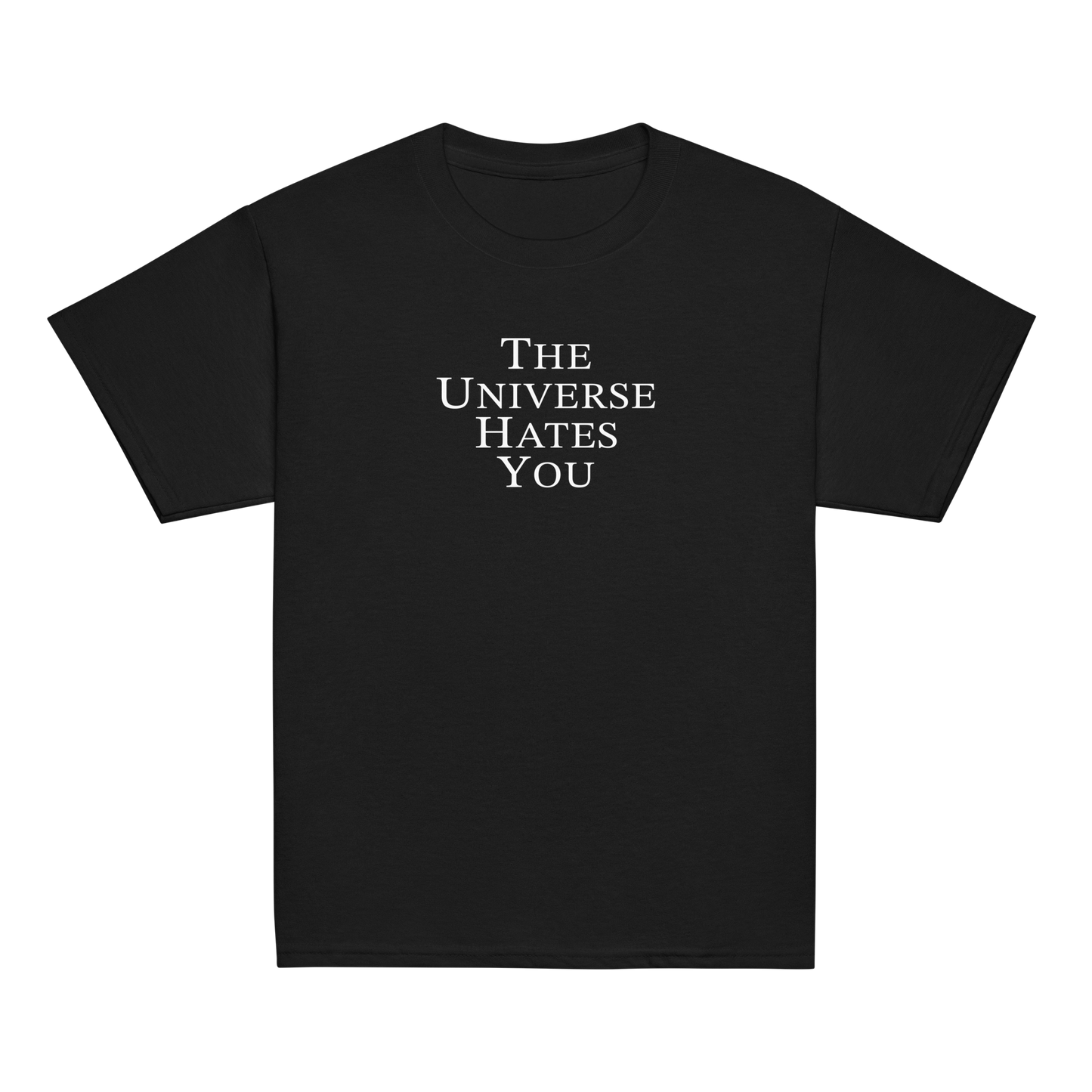 "The Universe Hates You" printed on a black youth classic tee laying on a flat surface