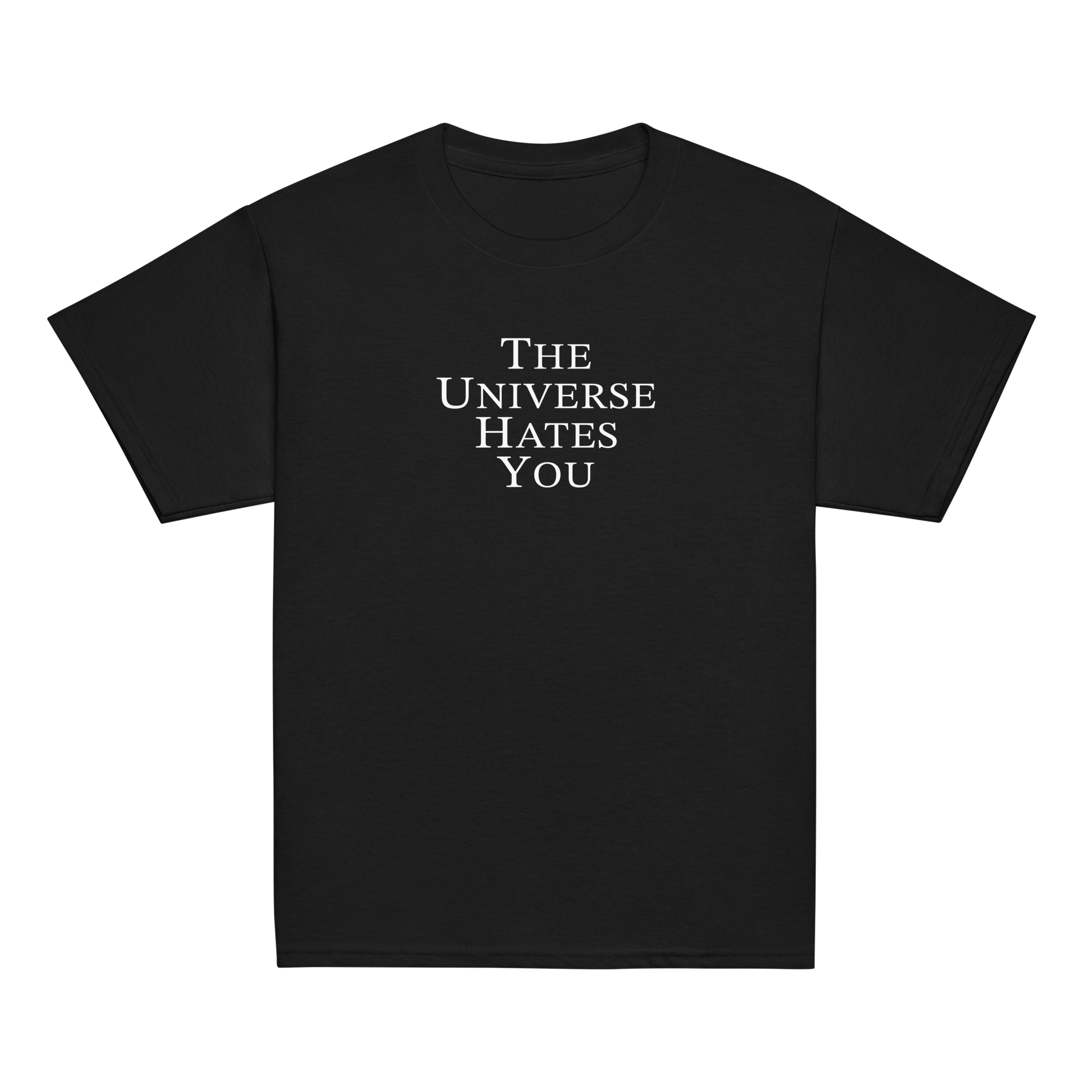 "The Universe Hates You" printed on a black youth classic tee laying on a flat surface