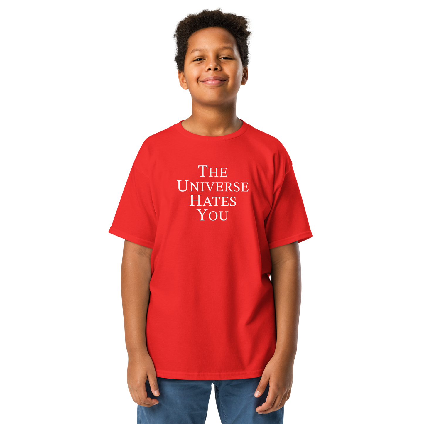 "The Universe Hates You" printed on a red youth classic tee worn by a male