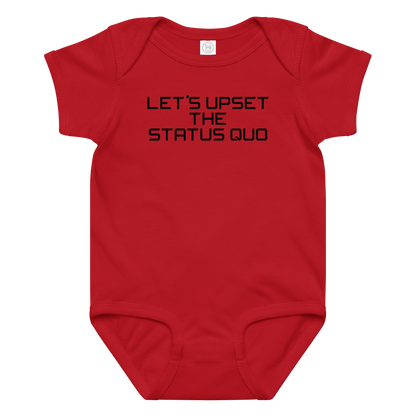 "Let's upset the status quo!" printed on a red baby jersey bodysuit laying on a flat surface amongst other clothes