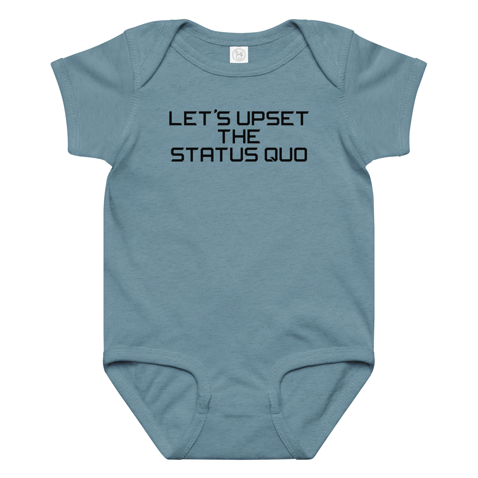 "Let's upset the status quo!" printed on a vintage indigo baby jersey bodysuit laying on a flat surface amongst other clothes