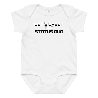 "Let's upset the status quo!" printed on a white baby jersey bodysuit laying on a flat surface amongst other clothes