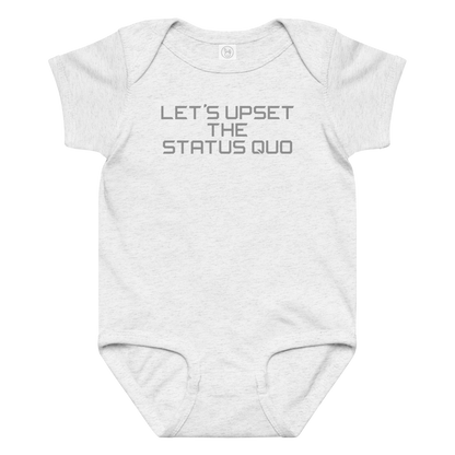 "Let's upset the status quo!" printed on a ash baby jersey bodysuit laying on a flat surface amongst other clothes