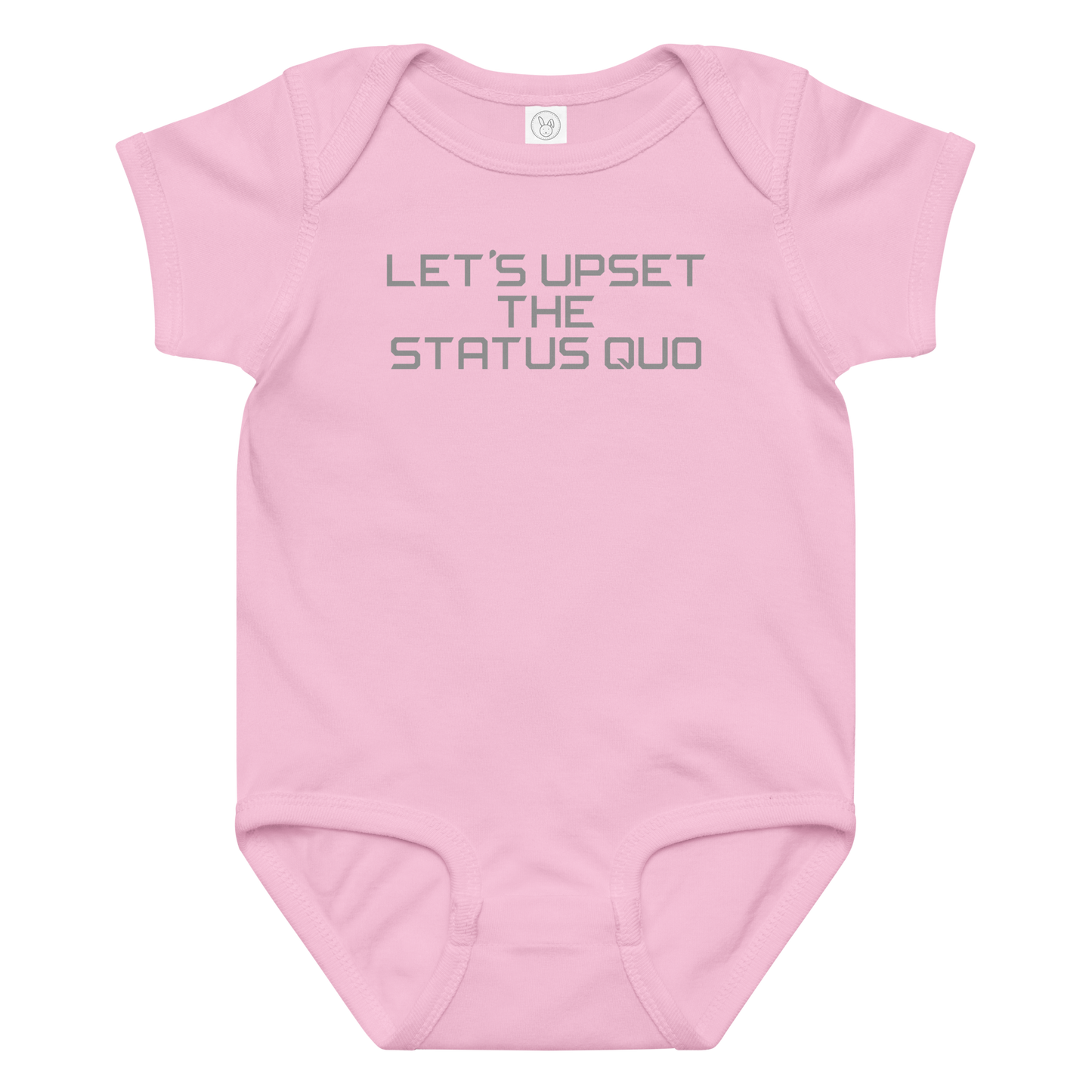 "Let's upset the status quo!" printed on a pink baby jersey bodysuit laying on a flat surface amongst other clothes
