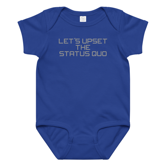 "Let's upset the status quo!" printed on a royal baby jersey bodysuit laying on a flat surface amongst other clothes