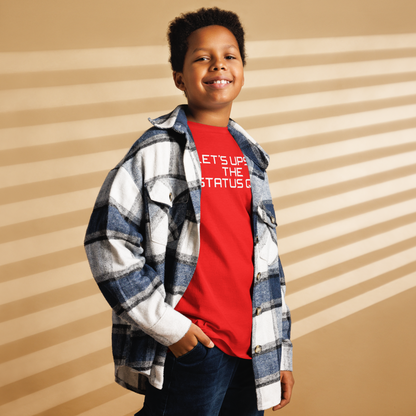 "Let's upset the status quo!" printed on a red youth classic tee worn by a male also wearing a jacket