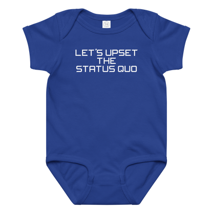 "Let's upset the status quo!" printed on a royal baby jersey bodysuit laying on a flat surface amongst other clothes