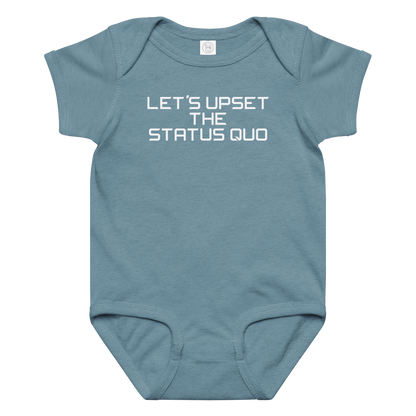 "Let's upset the status quo!" printed on a vintage indigo baby jersey bodysuit laying on a flat surface amongst other clothes