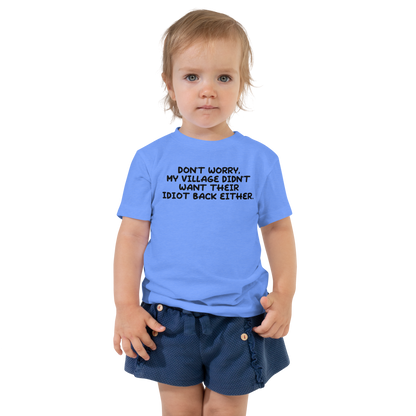"Don't worry, my village didn’t want their idiot back either." printed on a heather columbia blue toddler short sleeve tee worn by a female
