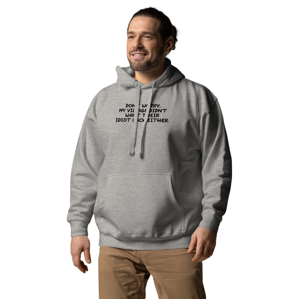 "Don't worry, my village didn’t want their idiot back either." printed on a carbon grey unisex hoodie worn by a male