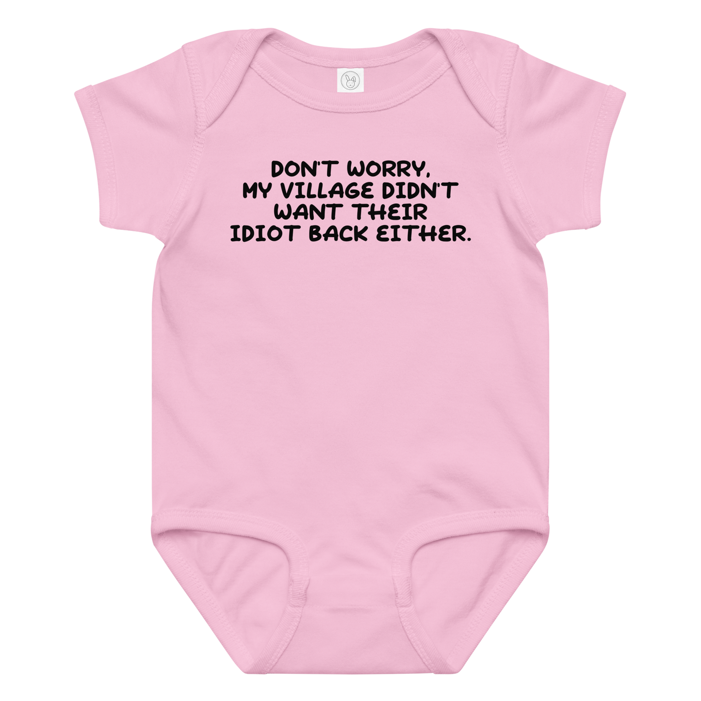 "Don't worry, my village didn’t want their idiot back either." printed on a pink baby jersey bodysuit laying on a flat surface amongst other clothes