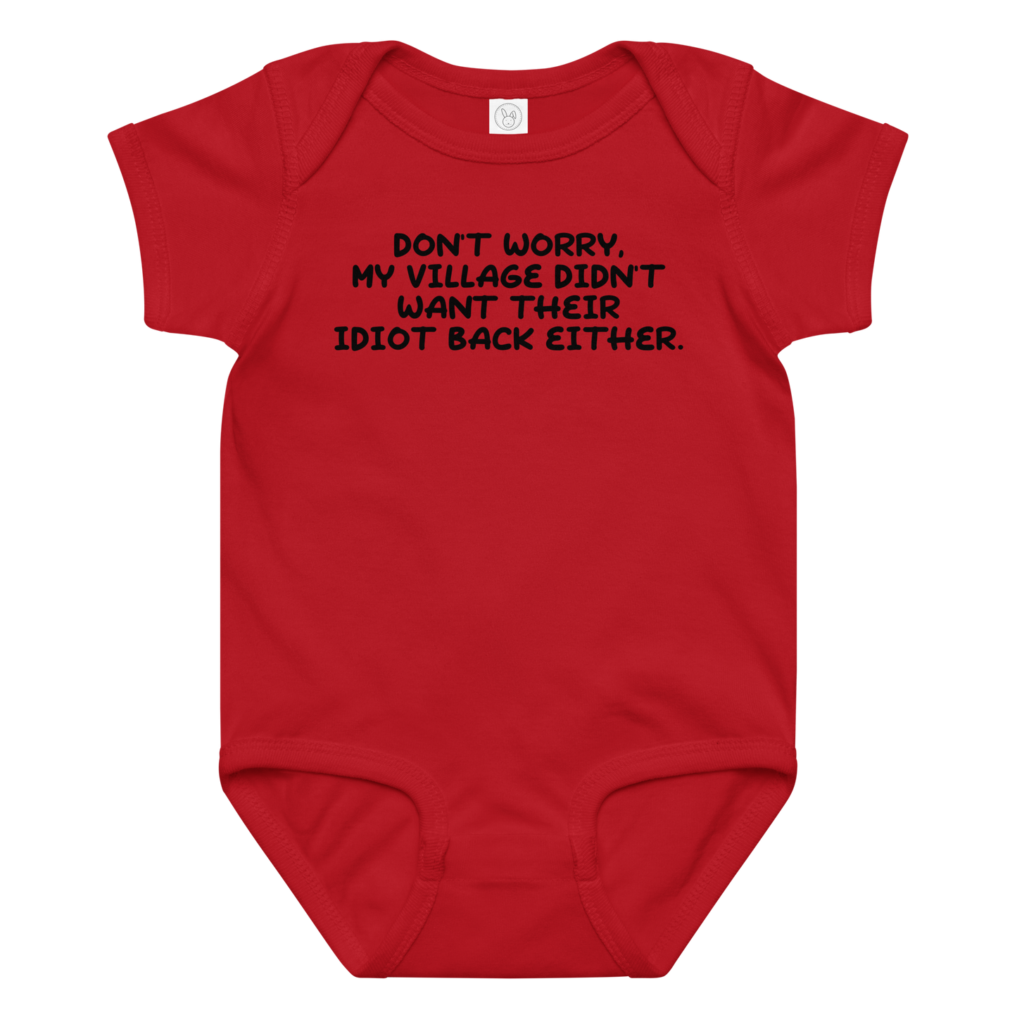 "Don't worry, my village didn’t want their idiot back either." printed on a red baby jersey bodysuit laying on a flat surface amongst other clothes