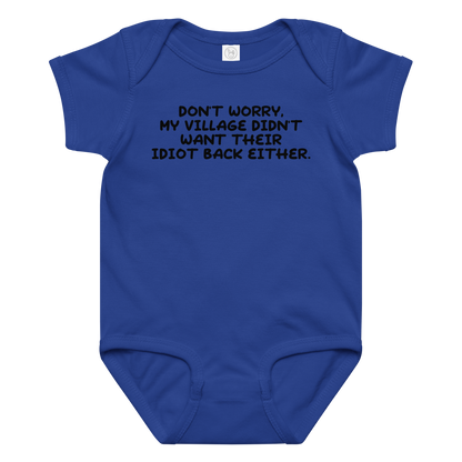 "Don't worry, my village didn’t want their idiot back either." printed on a royal baby jersey bodysuit laying on a flat surface amongst other clothes