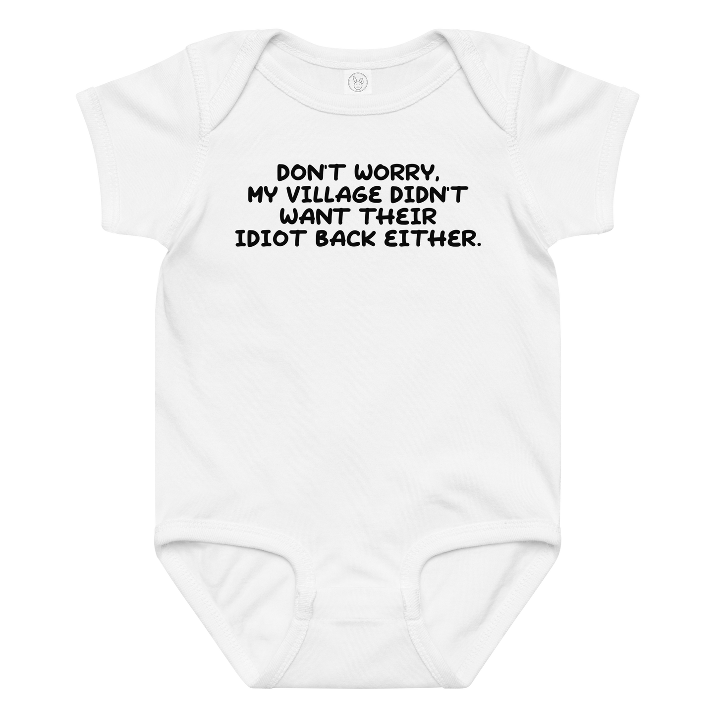 "Don't worry, my village didn’t want their idiot back either." printed on a white baby jersey bodysuit laying on a flat surface amongst other clothes