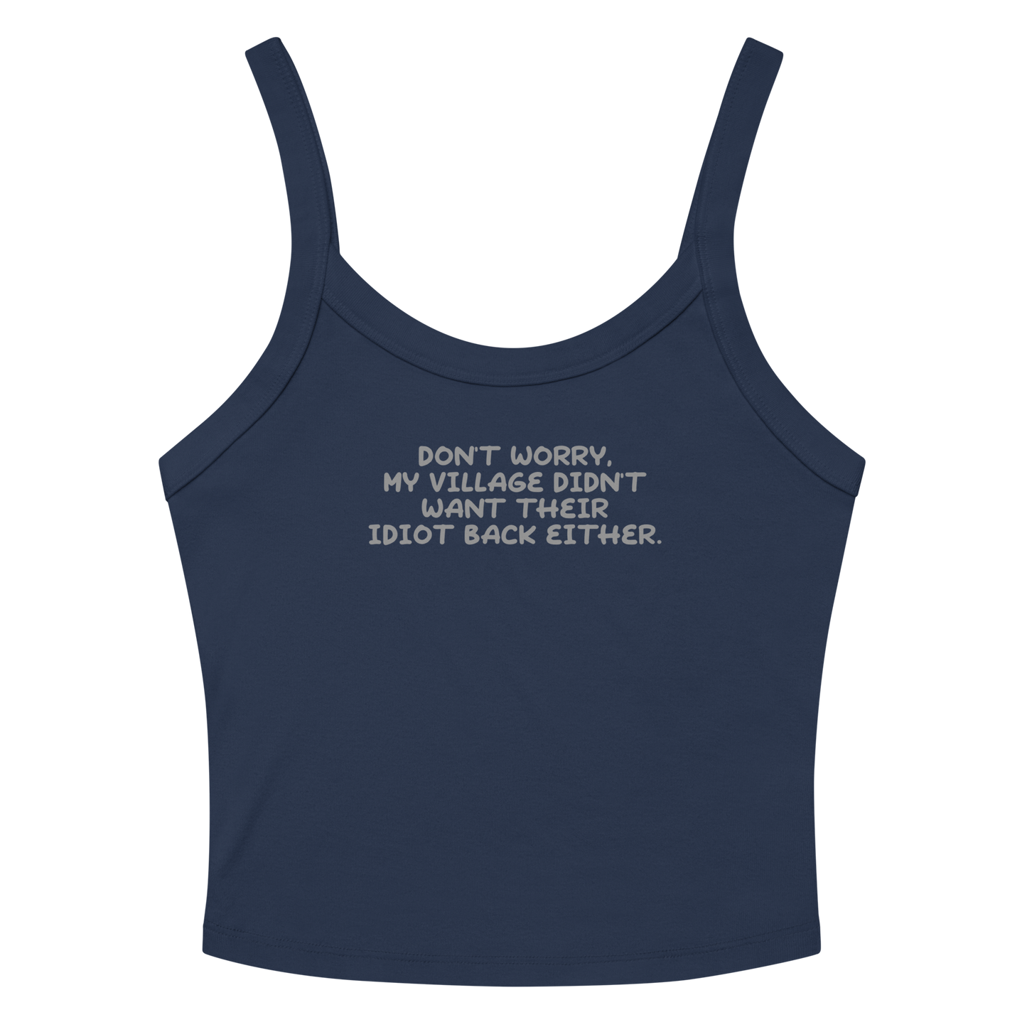 "Don't worry, my village didn’t want their idiot back either." printed on a solid navy blend women's micro-rib tanktop laying on a flat surface amongst sunglasses and shorts