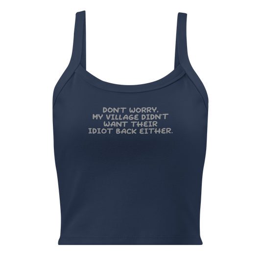 "Don't worry, my village didn’t want their idiot back either." printed on a solid navy blend women's micro-rib tanktop laying on a flat surface