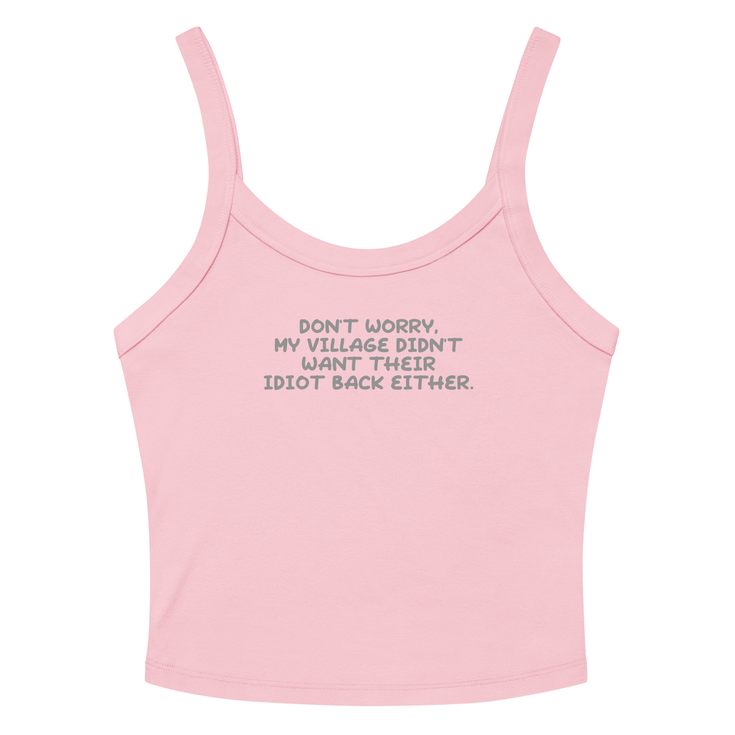 "Don't worry, my village didn’t want their idiot back either." printed on a solid pink blend women's micro-rib tanktop laying on a flat surface amongst sunglasses and shorts