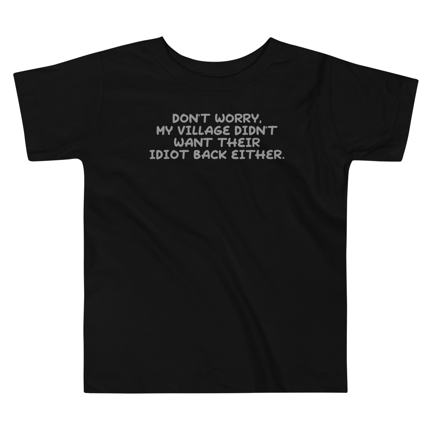"Don't worry, my village didn’t want their idiot back either." printed on a black toddler short sleeve tee laying on a flat surface