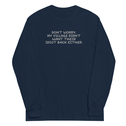 "Don't worry, my village didn’t want their idiot back either." printed on a navy men's long sleeve shirt laying on a flat surface
