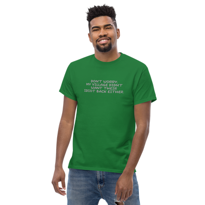 "Don't worry, my village didn’t want their idiot back either." printed on a turf green unisex classic tee worn by a male