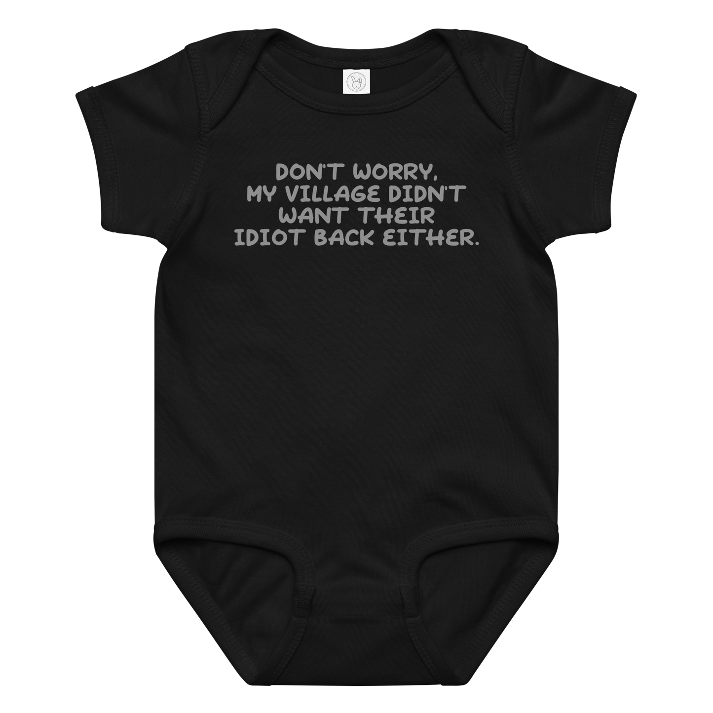 "Don't worry, my village didn’t want their idiot back either." printed on a black baby jersey bodysuit laying on a flat surface amongst other clothes