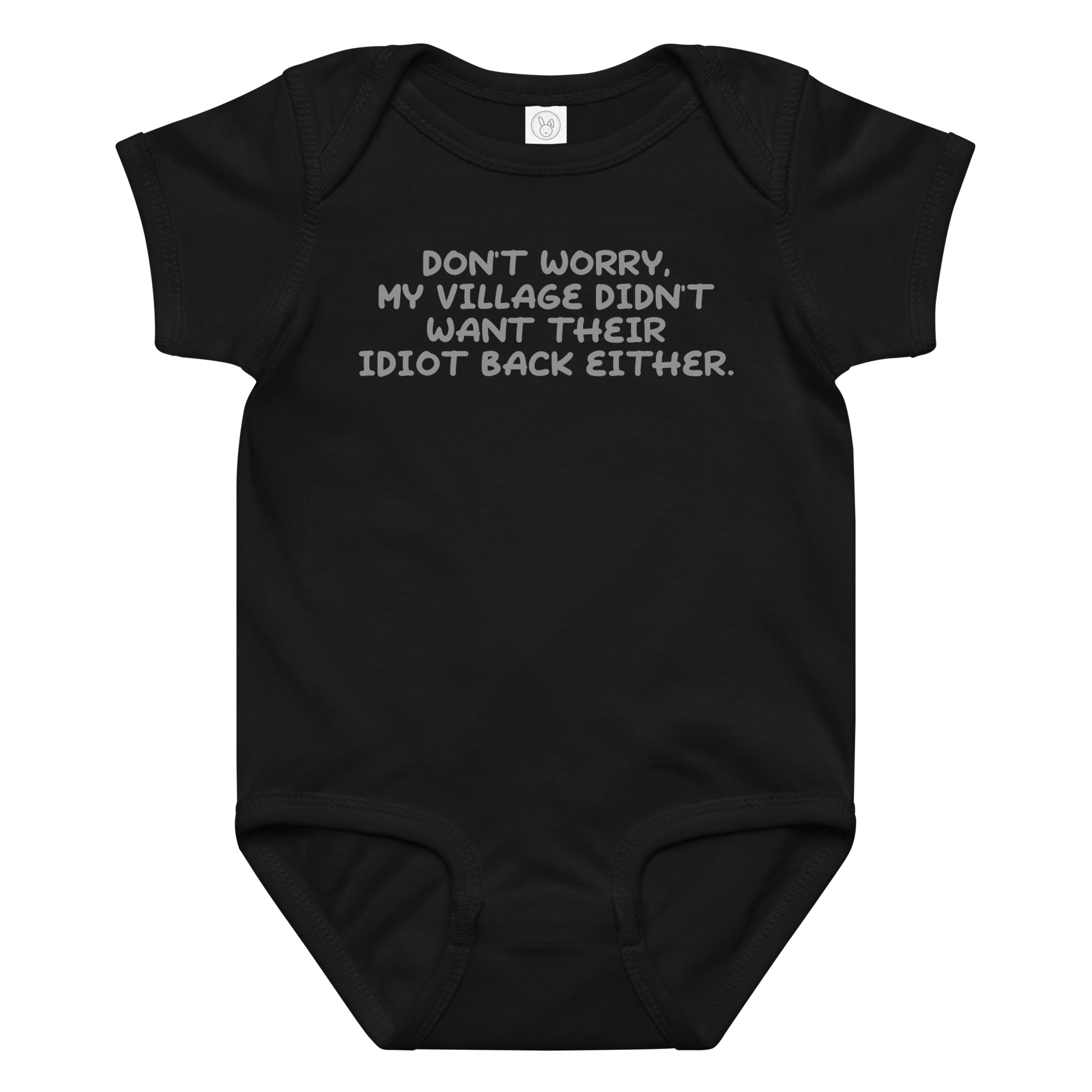 "Don't worry, my village didn’t want their idiot back either." printed on a black baby jersey bodysuit laying on a flat surface amongst other clothes