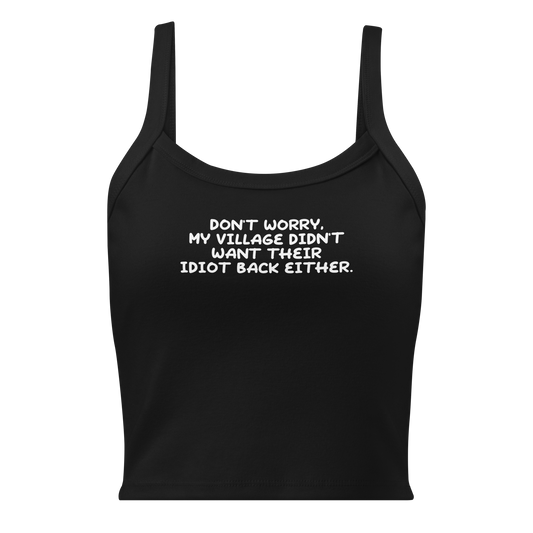 "Don't worry, my village didn’t want their idiot back either." printed on a solid black blend women's micro-rib tanktop laying on a flat surface