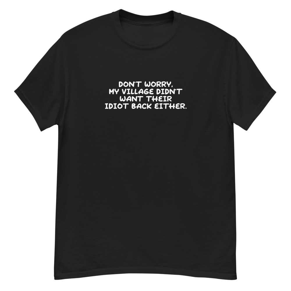 "Don't worry, my village didn’t want their idiot back either." printed on a black unisex classic tee laying on a flat surface