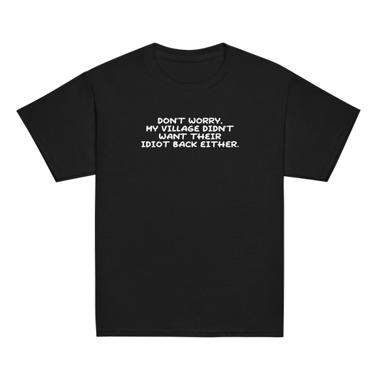 "Don't worry, my village didn’t want their idiot back either." printed on a black youth classic tee laying on a flat surface