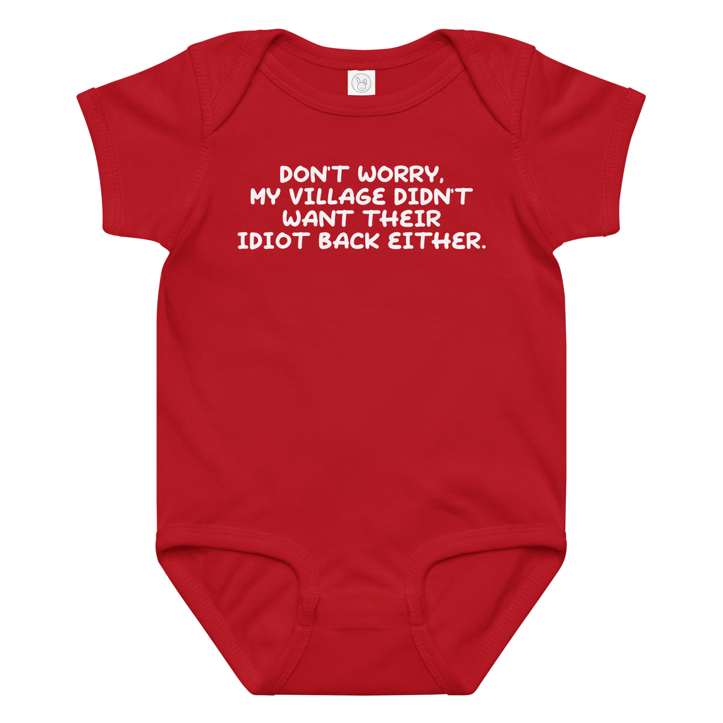 "Don't worry, my village didn’t want their idiot back either." printed on a red baby jersey bodysuit laying on a flat surface amongst other clothes