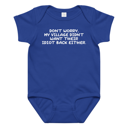 "Don't worry, my village didn’t want their idiot back either." printed on a royal baby jersey bodysuit laying on a flat surface amongst other clothes