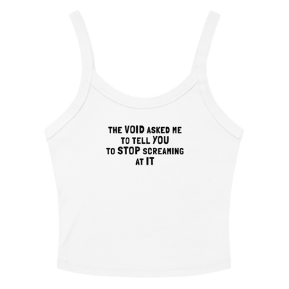 "The Void asked me to tell you to stop screaming at it" printed on a solid white blend women's micro-rib tanktop laying on a flat surface amongst sunglasses and shorts