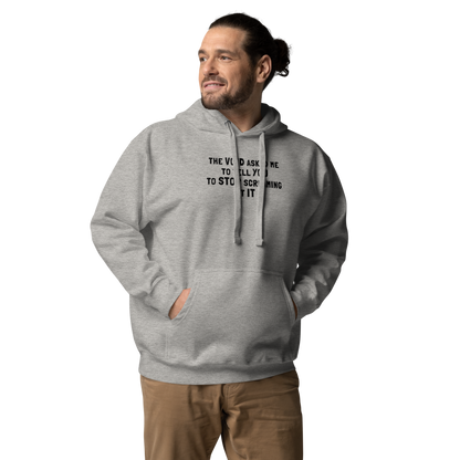 "The Void asked me to tell you to stop screaming at it" printed on a carbon grey unisex hoodie worn by a male