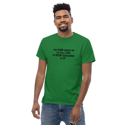 "The Void asked me to tell you to stop screaming at it" printed on a turf green unisex classic tee worn by a male