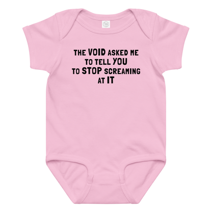 "The Void asked me to tell you to stop screaming at it" printed on a pink baby jersey bodysuit laying on a flat surface amongst other clothes