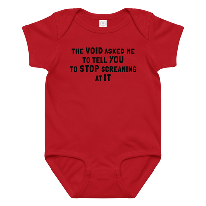 "The Void asked me to tell you to stop screaming at it" printed on a red baby jersey bodysuit laying on a flat surface amongst other clothes