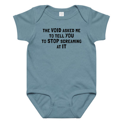 "The Void asked me to tell you to stop screaming at it" printed on a vintage indigo baby jersey bodysuit laying on a flat surface amongst other clothes