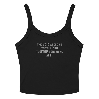 "The Void asked me to tell you to stop screaming at it" printed on a solid black blend women's micro-rib tanktop laying on a flat surface amongst sunglasses and shorts