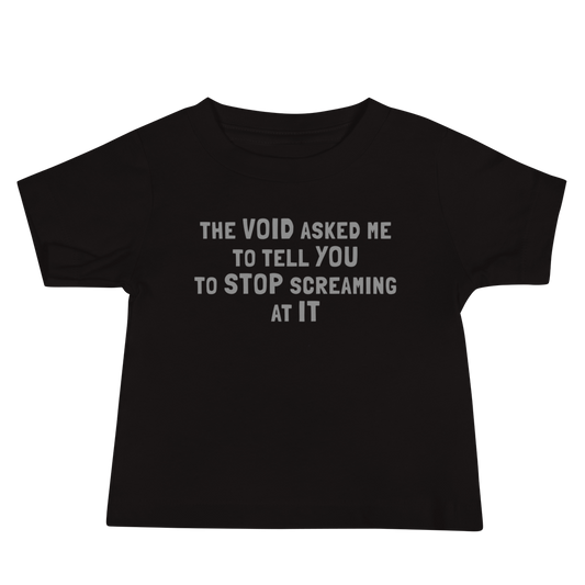 "The Void asked me to tell you to stop screaming at it" printed on a black baby jersey short sleeve tee laying on a flat surface