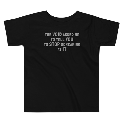 "The Void asked me to tell you to stop screaming at it" printed on a black toddler short sleeve tee laying on a flat surface