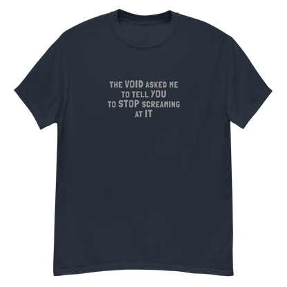 "The Void asked me to tell you to stop screaming at it" printed on a navy unisex classic tee laying on a flat surface