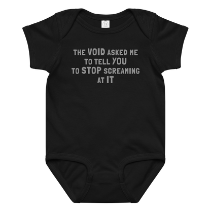 "The Void asked me to tell you to stop screaming at it" printed on a black baby jersey bodysuit laying on a flat surface amongst other clothes