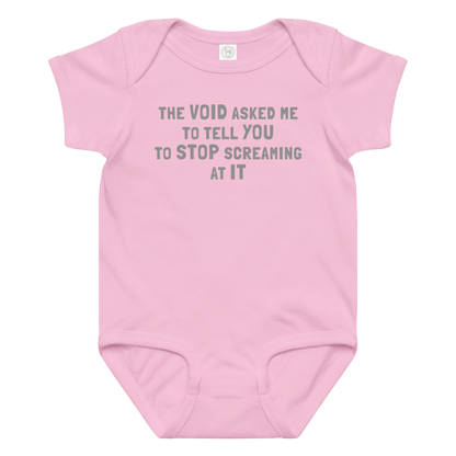 "The Void asked me to tell you to stop screaming at it" printed on a pink baby jersey bodysuit laying on a flat surface amongst other clothes