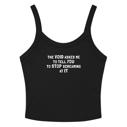 "The Void asked me to tell you to stop screaming at it" printed on a solid black blend women's micro-rib tanktop laying on a flat surface amongst sunglasses and shorts