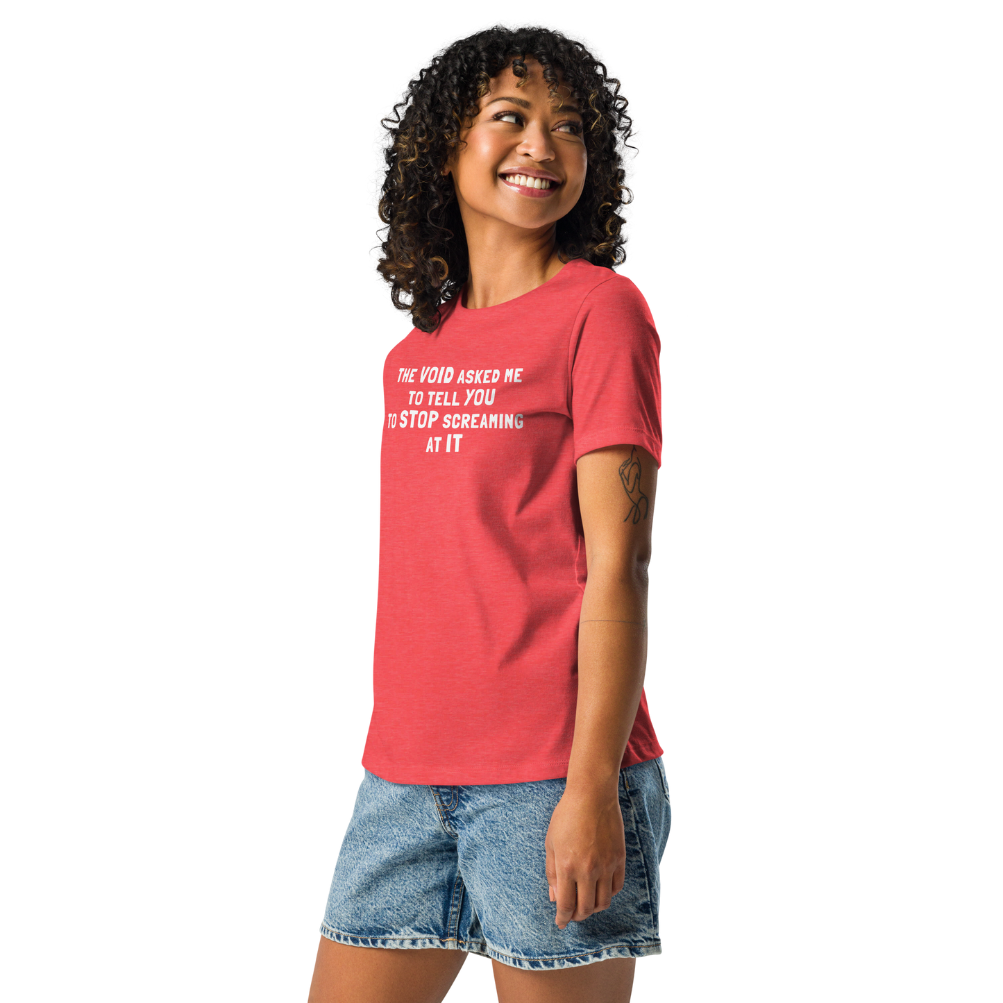 "The Void asked me to tell you to stop screaming at it" printed on a heather red women's relaxed t-shirt worn by a female