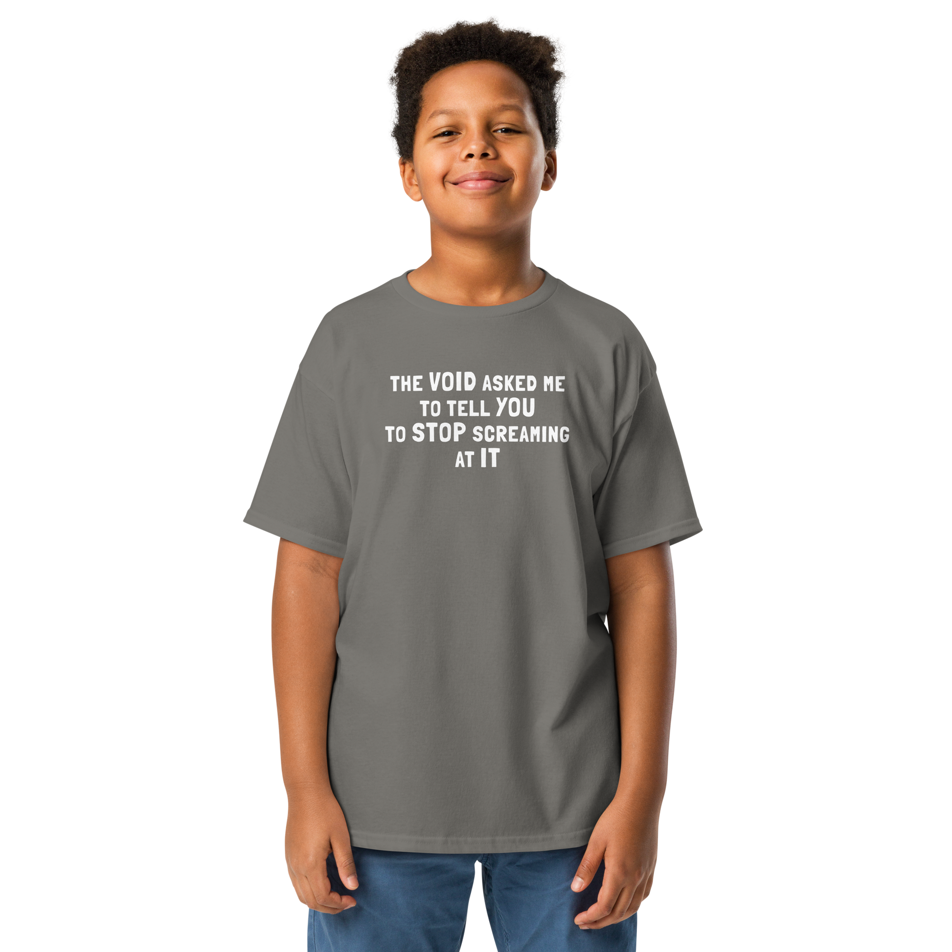 "The Void asked me to tell you to stop screaming at it" printed on a charcoal youth classic tee worn by a male
