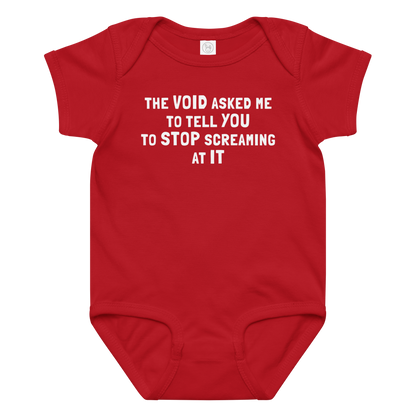 "The Void asked me to tell you to stop screaming at it" printed on a red baby jersey bodysuit laying on a flat surface amongst other clothes
