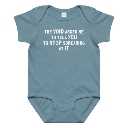 "The Void asked me to tell you to stop screaming at it" printed on a vintage indigo baby jersey bodysuit laying on a flat surface amongst other clothes